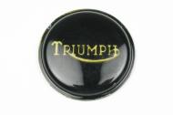 This is the black and gold badge for a top cover of a gas tank on a triumph motorcycle.