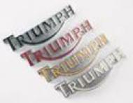 This is a silver side of tank decal that reads ---Triumph---
